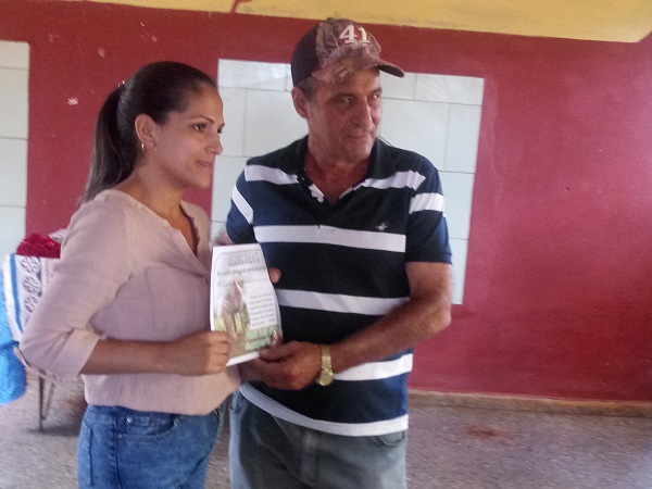 Mariolis Martínez, presidenta de la ANAP en el territorio, entrega un reconocimiento a frank González, presidente de la Cooperativa de Producción Agropecuaria Augusto César Sandino. Fotos: Carmen Lieng Mena.