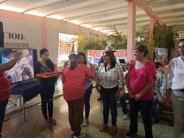 Teresa Amarelle Boue, Secretaria General de la FMC, entrega los sellos 60 ANIVERSARIO de la FMC.